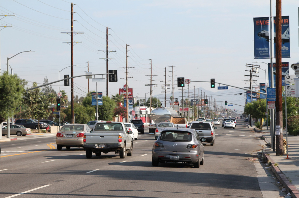 Photograph of a wide road with cars driving on it.