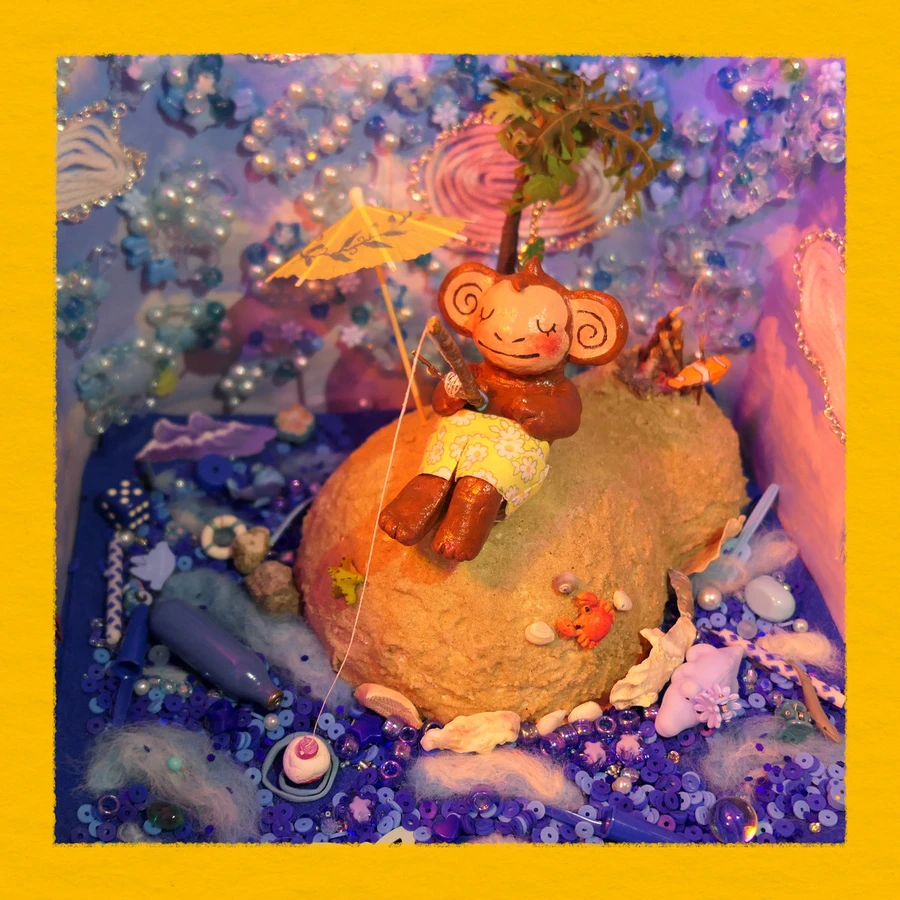A monkey goes fishing on a small island in a diorama made from beads and clay.